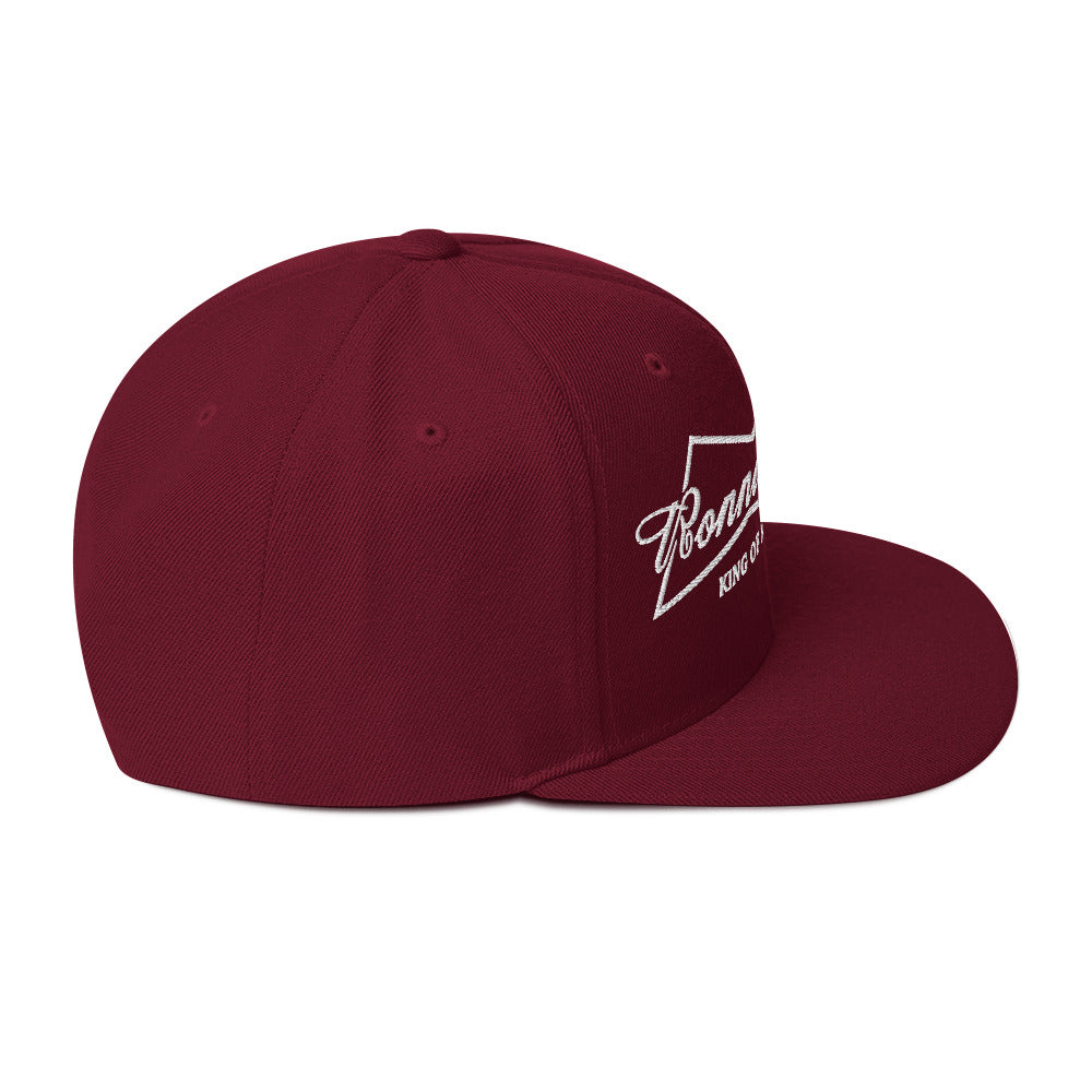 Burgundy King of Moto embroidered snapback hat with classic fit and flat brim, featuring adjustable plastic snap closure.