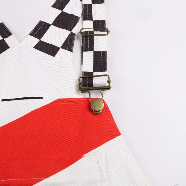 Close-up of Macboro Overalls showcasing black and white checkered straps and bold red accent on white fabric