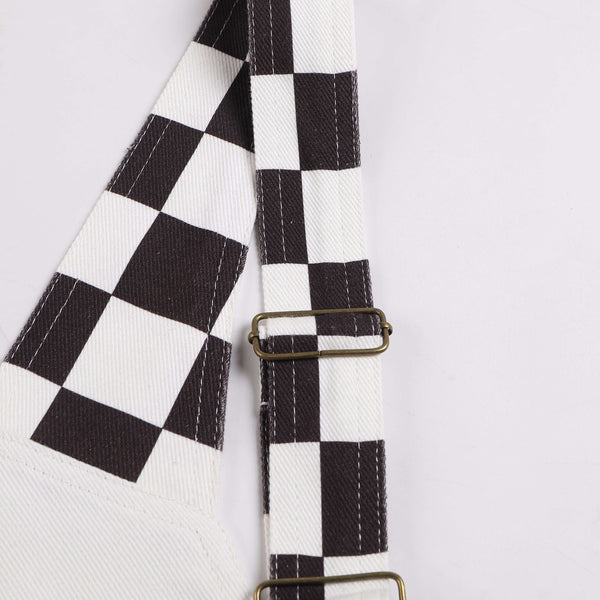 Close-up of Macboro Overalls strap with black and white checkered pattern and metal buckle