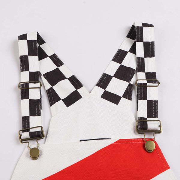 Close-up of Macboro Overalls showing black and white checkered straps and red detailing, representing strength, grit, and endurance.