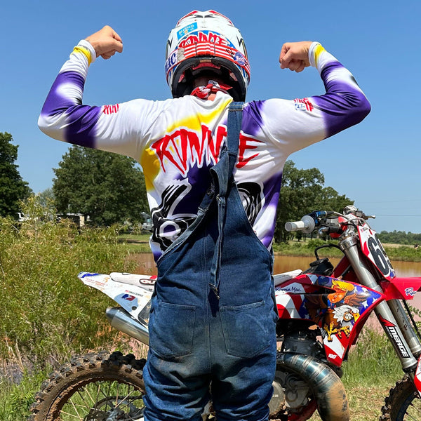 Ronnie Mac wearing the retro jersey standing by the magnum eagle at the track flexing his muscles